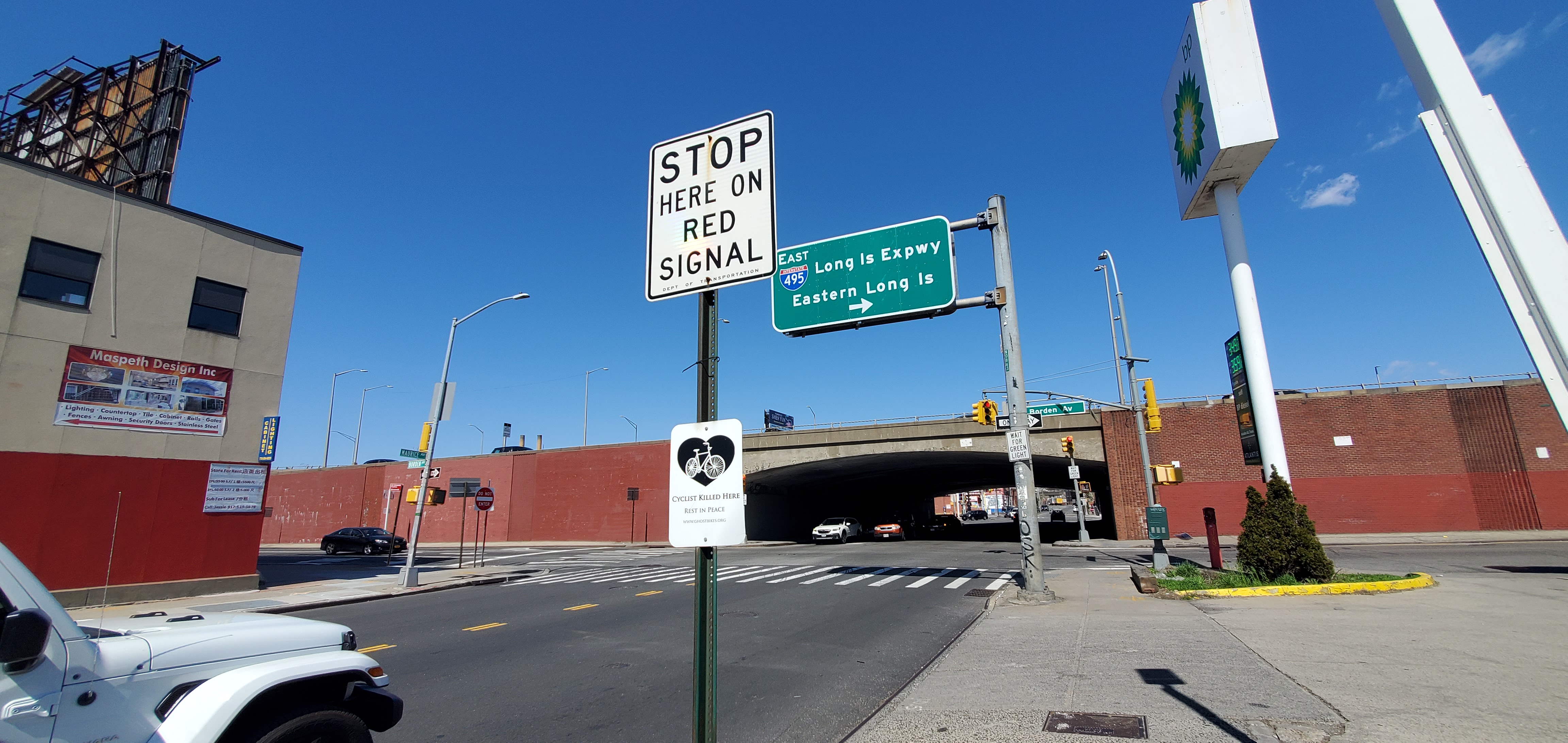 White plaque attached to street sign near highway entrance